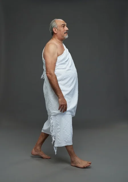 Saudi Man in Ihram Walking Against Grey Background Studio