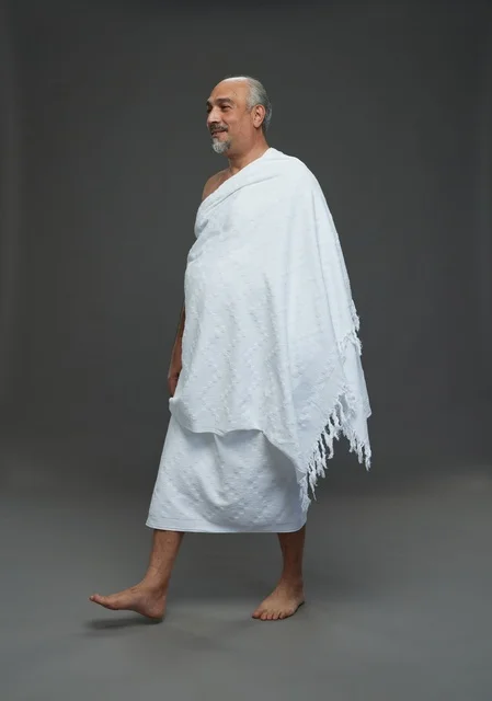 رجل سعودي بملابس الإحرام يسير أثناء أداء المناسك