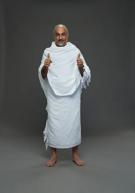 Smiling Saudi Man in Ihram Clothing on Grey Background