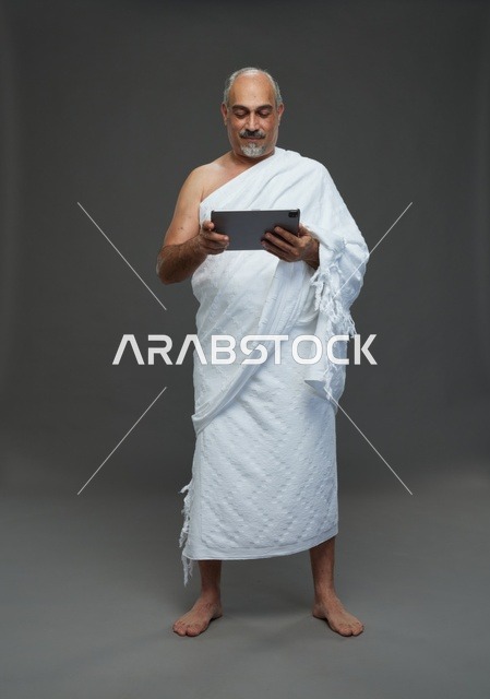 Saudi Man in Ihram Using Tablet Studio Portrait