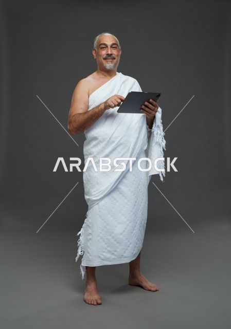 Saudi Man in Ihram Using Tablet in Studio