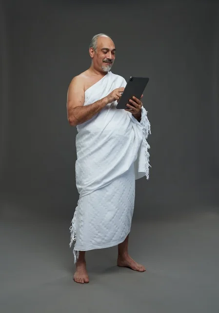 Saudi Man in Ihram Clothing Using Digital Tablet Studio