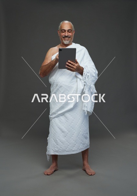 Saudi Man in Ihram Using Digital Tablet