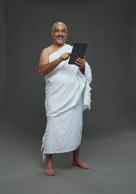 رجل سعودي بملابس الإحرام يستخدم جهازاً لوحياً في الاستوديو