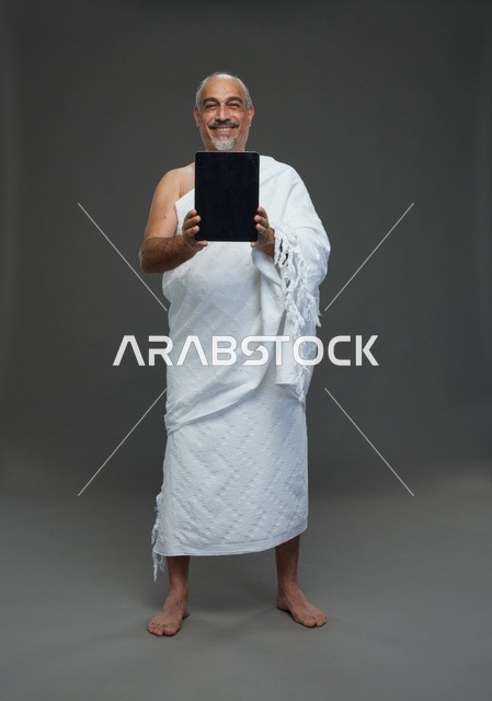 Saudi man in Ihram using a tablet