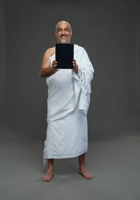 Saudi man in Ihram using a tablet
