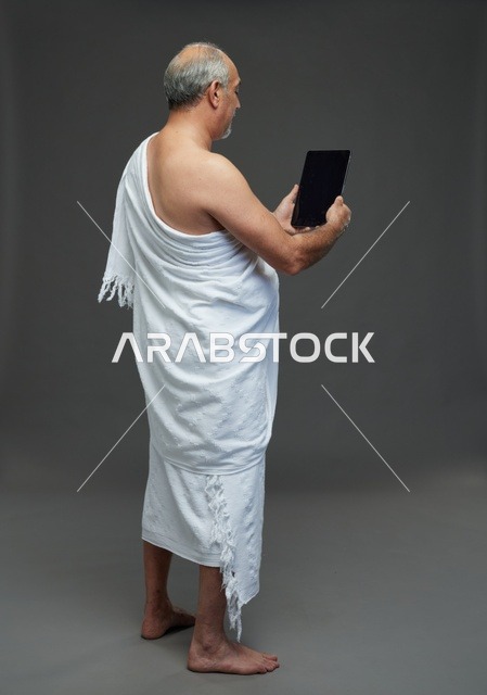 Saudi Man in Ihram Using Digital Tablet