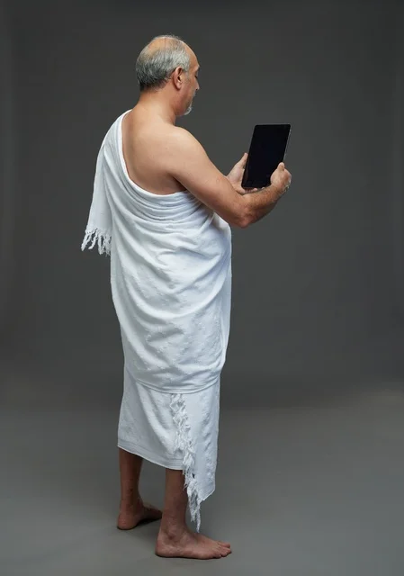 Saudi Man in Ihram Using Digital Tablet