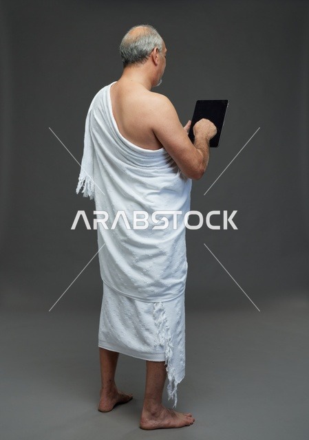 Saudi Man in Ihram Using Tablet in Studio