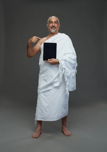 Saudi Man in Ihram Holding Tablet Device