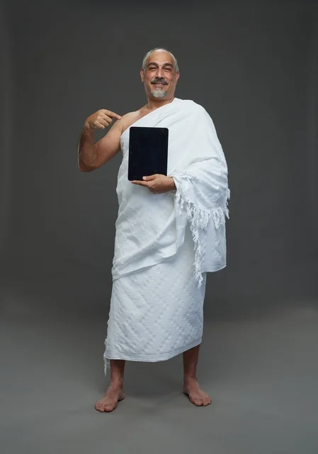 Saudi Man in Ihram Holding Tablet in Studio