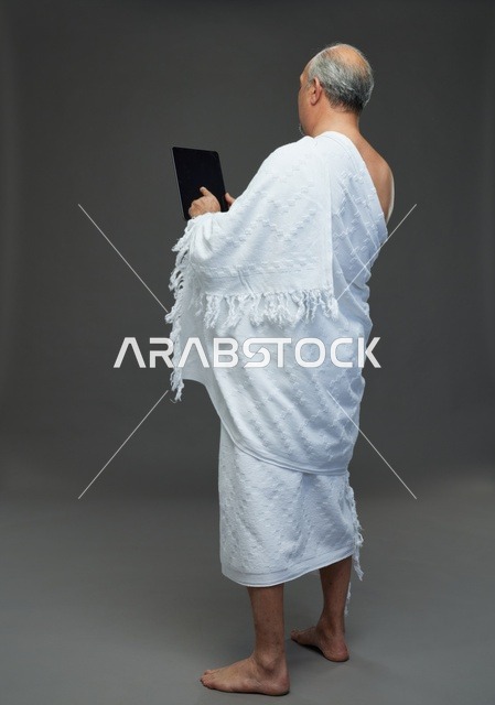 Saudi Man in Ihram Using Digital Tablet in Studio Setting