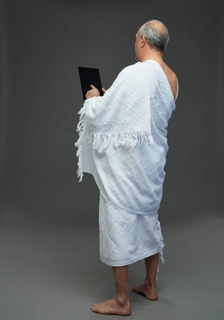 Saudi Man in Ihram Using Digital Tablet in Studio Setting