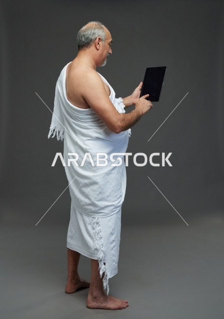 Saudi Man in Ihram Using Digital Tablet Studio