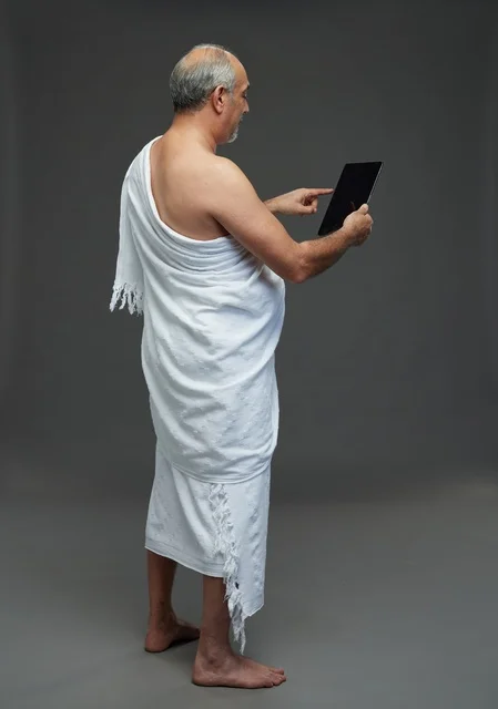 Saudi Pilgrim in Ihram Using Tablet Studio Shot