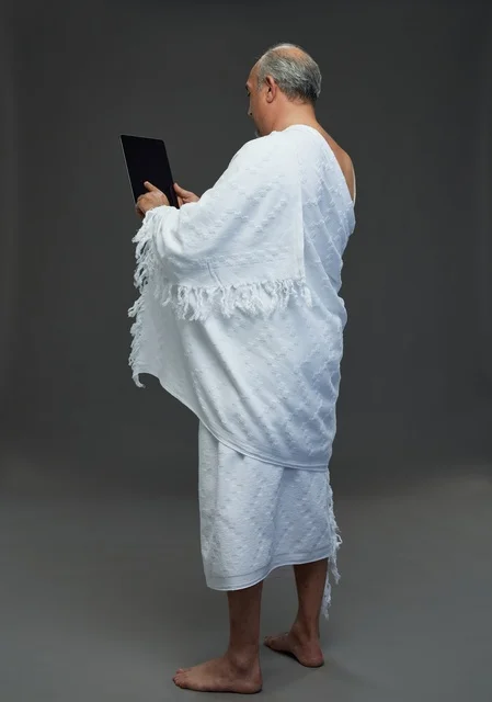 Saudi Man in Ihram Using Tablet Device