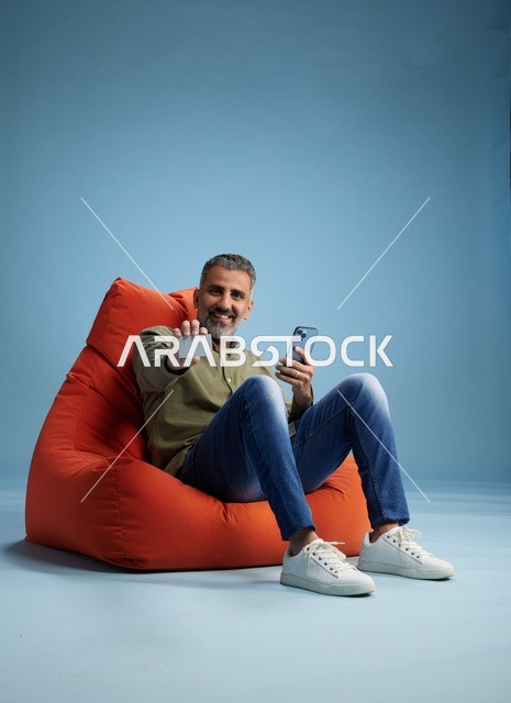 رجل سعودي يمسك بطاقة ائتمان وهاتف ذكي