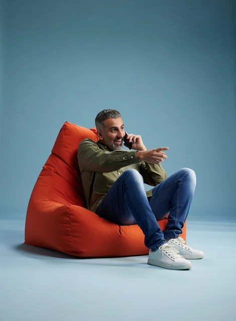 رجل سعودي يتحدث بالهاتف جالساً على بين باج