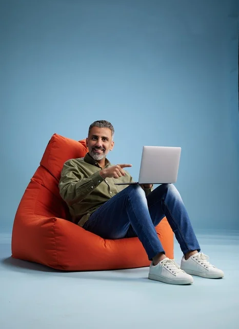 Saudi Man Using Laptop on Orange Bean Bag