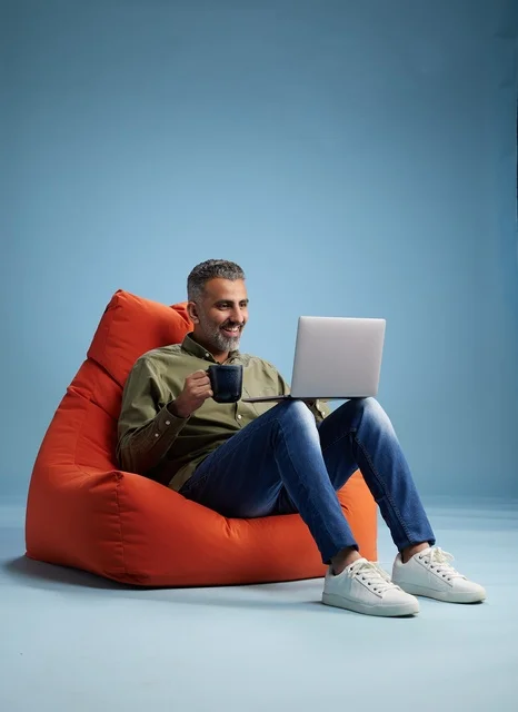 Saudi Man Working on Laptop in Bean Bag Chair