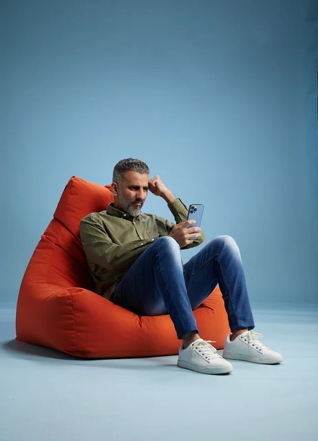 Saudi Man Sitting in Bean Bag Looking at Smartphone