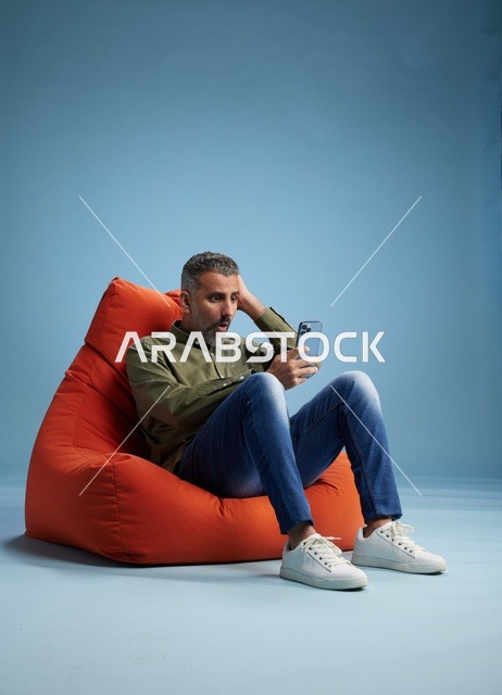 Surprised Saudi Man Using Smartphone in Studio