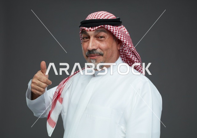 رجل سعودي بالزي التقليدي يشير بالإبهام للأعلى