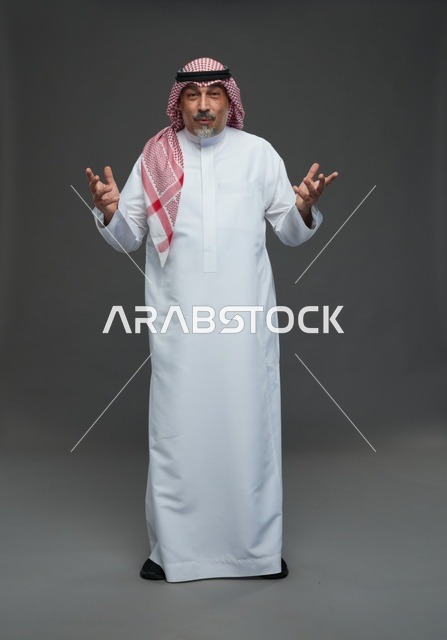 رجل سعودي بالزي التقليدي يلوح بيديه في الاستوديو