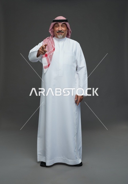 رجل سعودي بالزي التقليدي يشير بإصبعه في استوديو تصوير