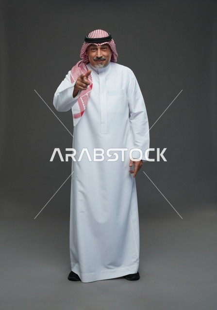 Saudi Man in Traditional Thobe Pointing at Camera