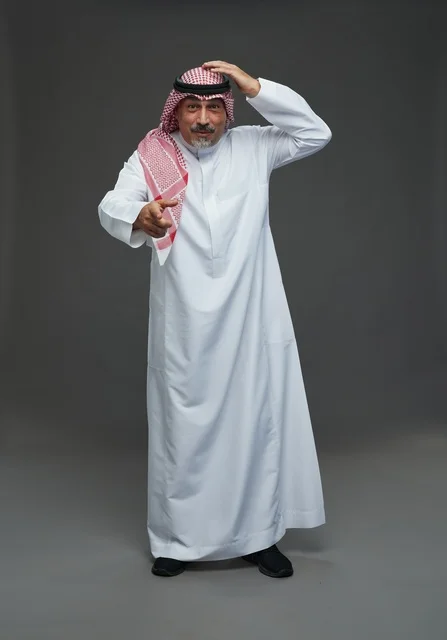 رجل سعودي بالزي التقليدي يشير للأمام بتعبير وجه حائر