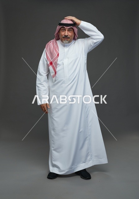 رجل سعودي بالزي التقليدي بتعبير مندهش خلفية رمادية
