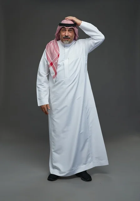 رجل سعودي بالزي التقليدي بتعبير مندهش خلفية رمادية