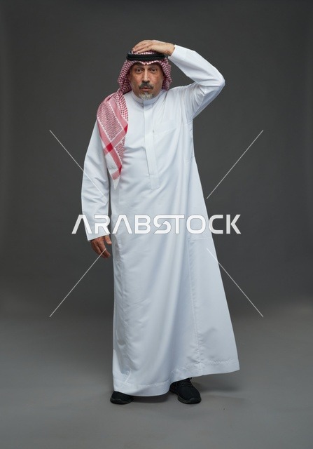 رجل سعودي بالزي التقليدي بتعبير وجه يدل على الحيرة
