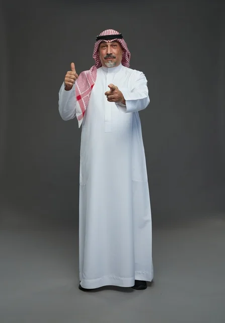رجل سعودي بالثوب والشماغ يشير بيده في استوديو