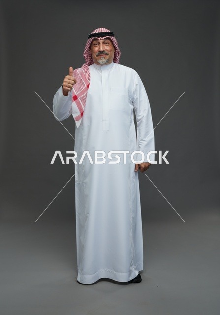 رجل سعودي بالزي التقليدي يشير بعلامة الإعجاب