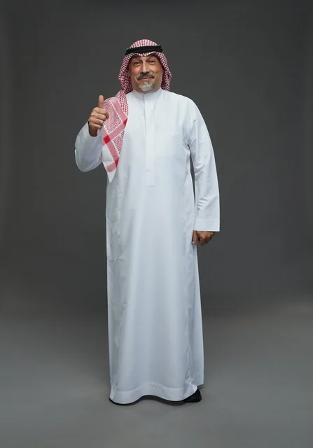 رجل سعودي بالزي التقليدي يشير بعلامة الإعجاب