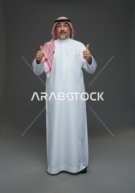 رجل سعودي بالزي التقليدي يرفع إبهامه علامة للموافقة