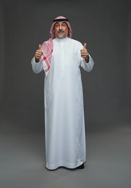 رجل سعودي بالزي التقليدي يرفع إبهامه علامة للموافقة