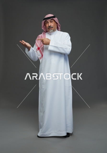 رجل سعودي بالزي التقليدي يشير بيده