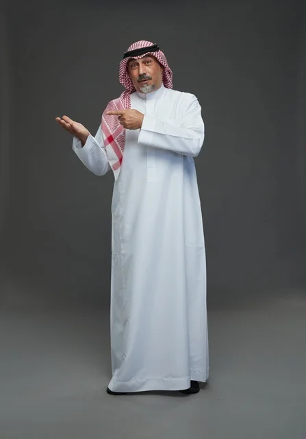 Saudi Man in Traditional Dress Pointing at Palm