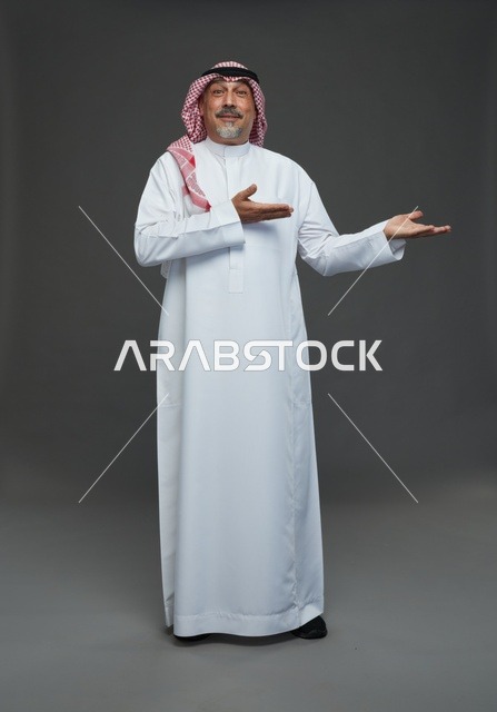 رجل سعودي بالزي التقليدي يشير بيده في الاستوديو