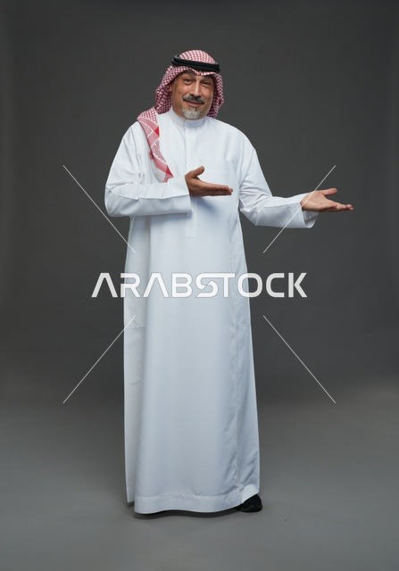 رجل سعودي بالزي التقليدي يشير بيده في الاستوديو