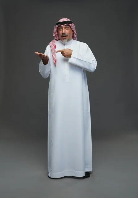 رجل سعودي بالزي التقليدي يشير إلى يده