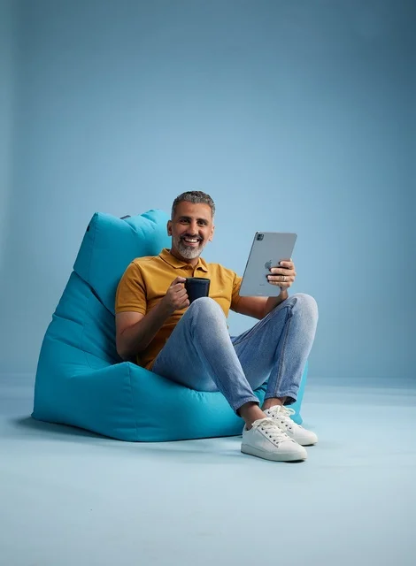 Saudi Man on Beanbag with Tablet and Coffee