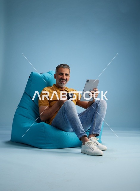Saudi Man with Tablet and Coffee on Bean Bag