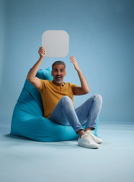 رجل سعودي يحمل لوحة موك أب بيضاء على كرسي