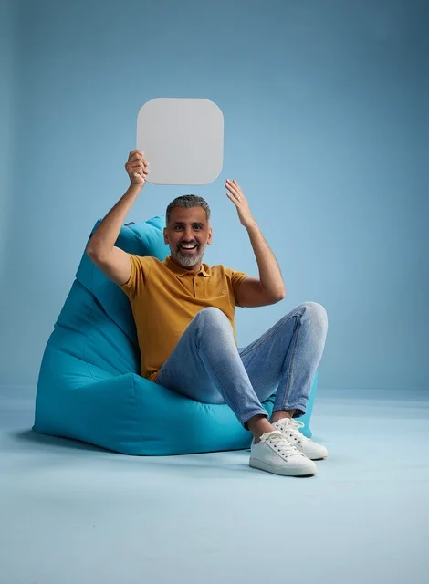 Saudi Man Holding Blank Mockup Board on Bean Bag