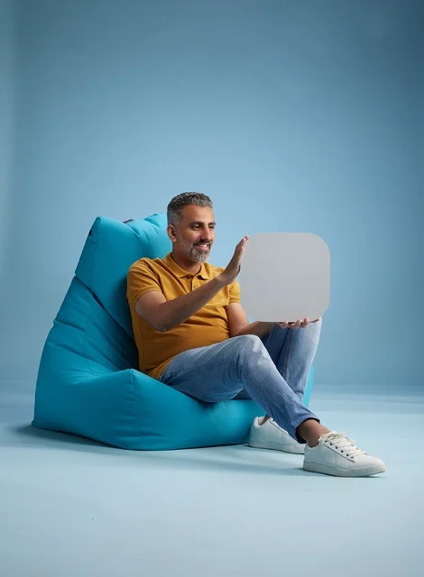 رجل سعودي يحمل لوحة موك أب فارغة على كرسي