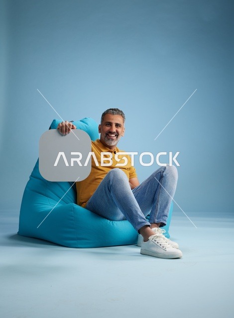 رجل سعودي على بين باج يحمل لوحة موك أب فارغة